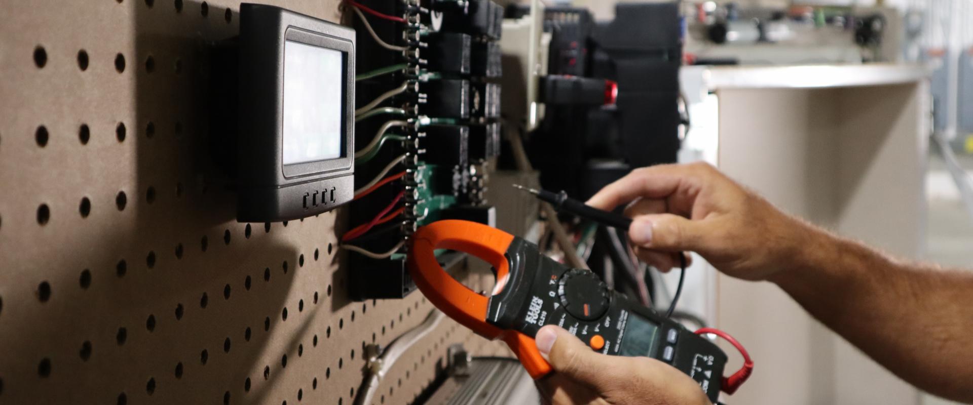 Hands working on electronics training board