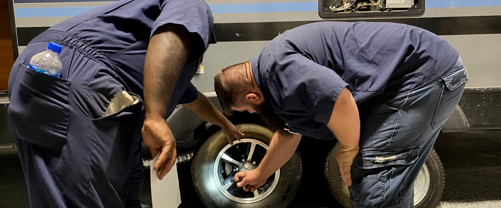 two technicians checking a wheel