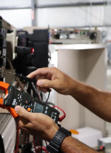 Hands working on electronics training board