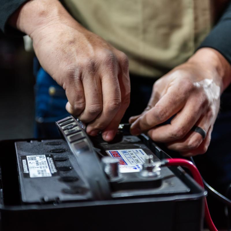 Hands working on an RV battery