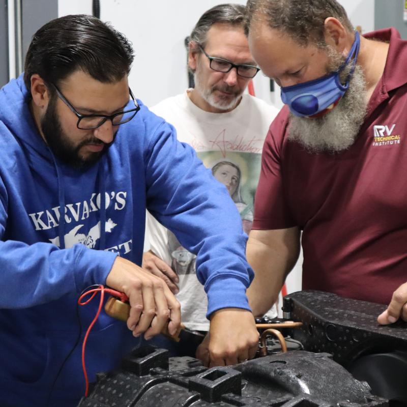 Technicians working on tutorial RV engine