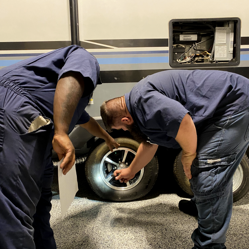 two technicians checking a wheel