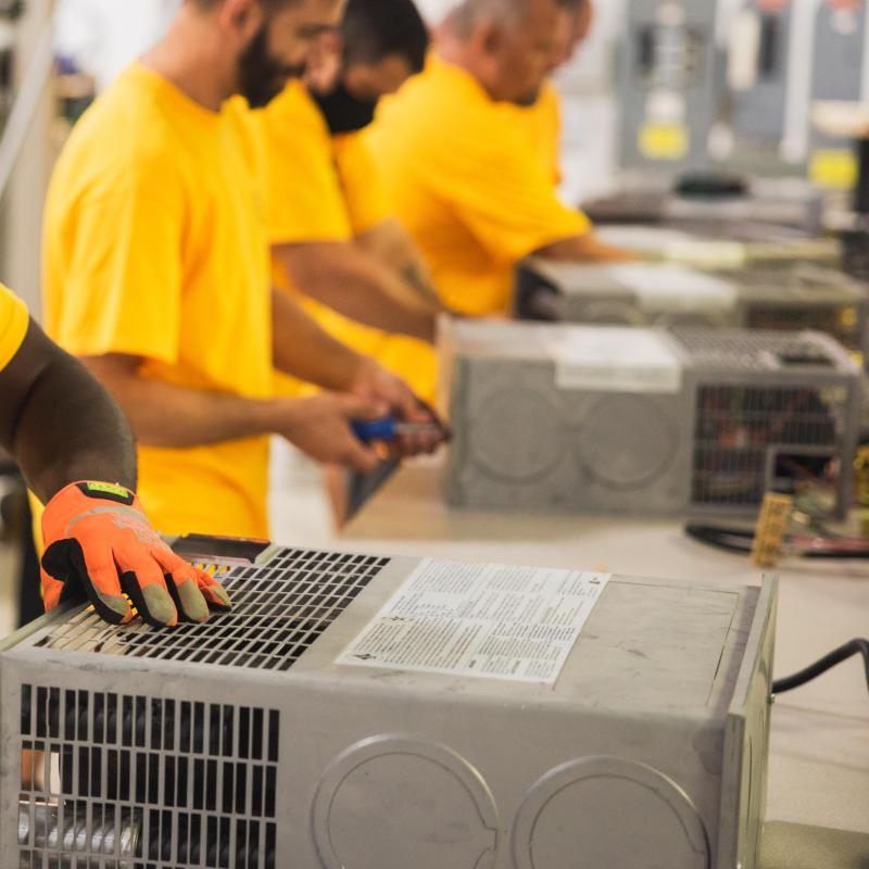 Technician working on a box with vents and wires