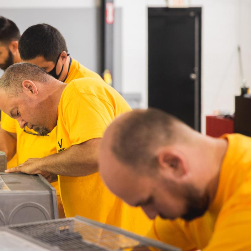 Group of technicians training on equipment