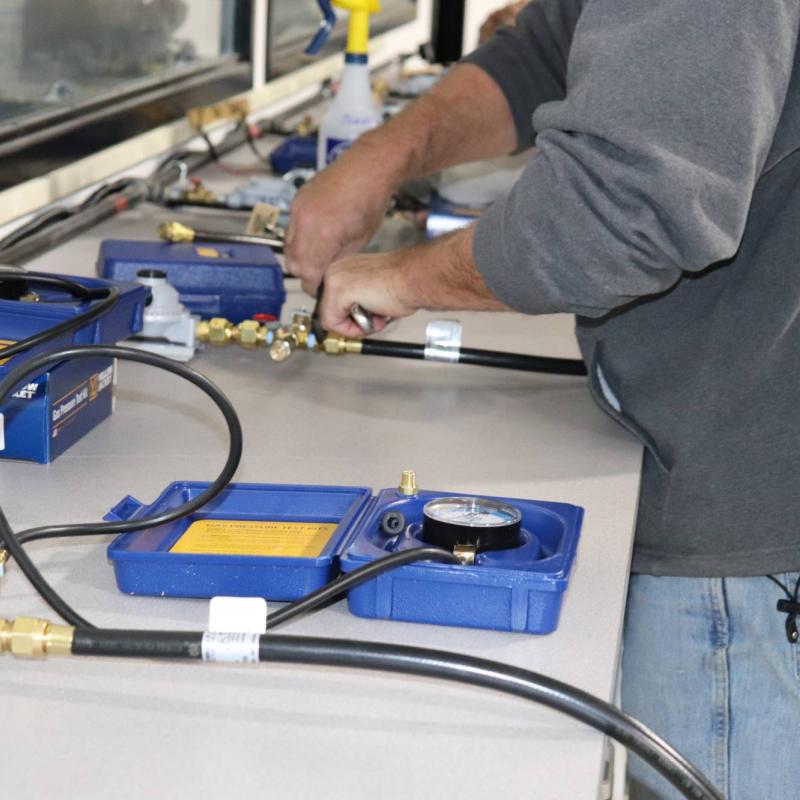 technician learning to work with hoses and gauges
